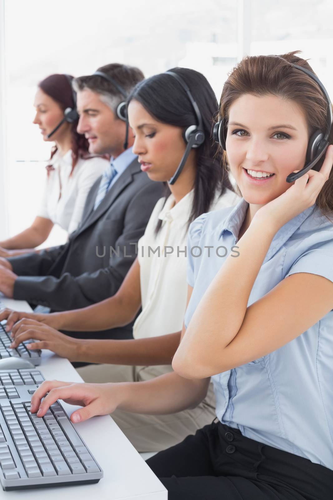 Employees typing on their computers using headsets