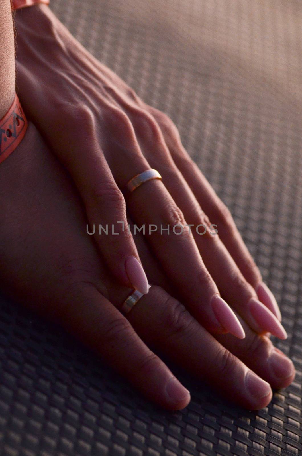 Newlyweds hands with wedding rings on the finger clasped together