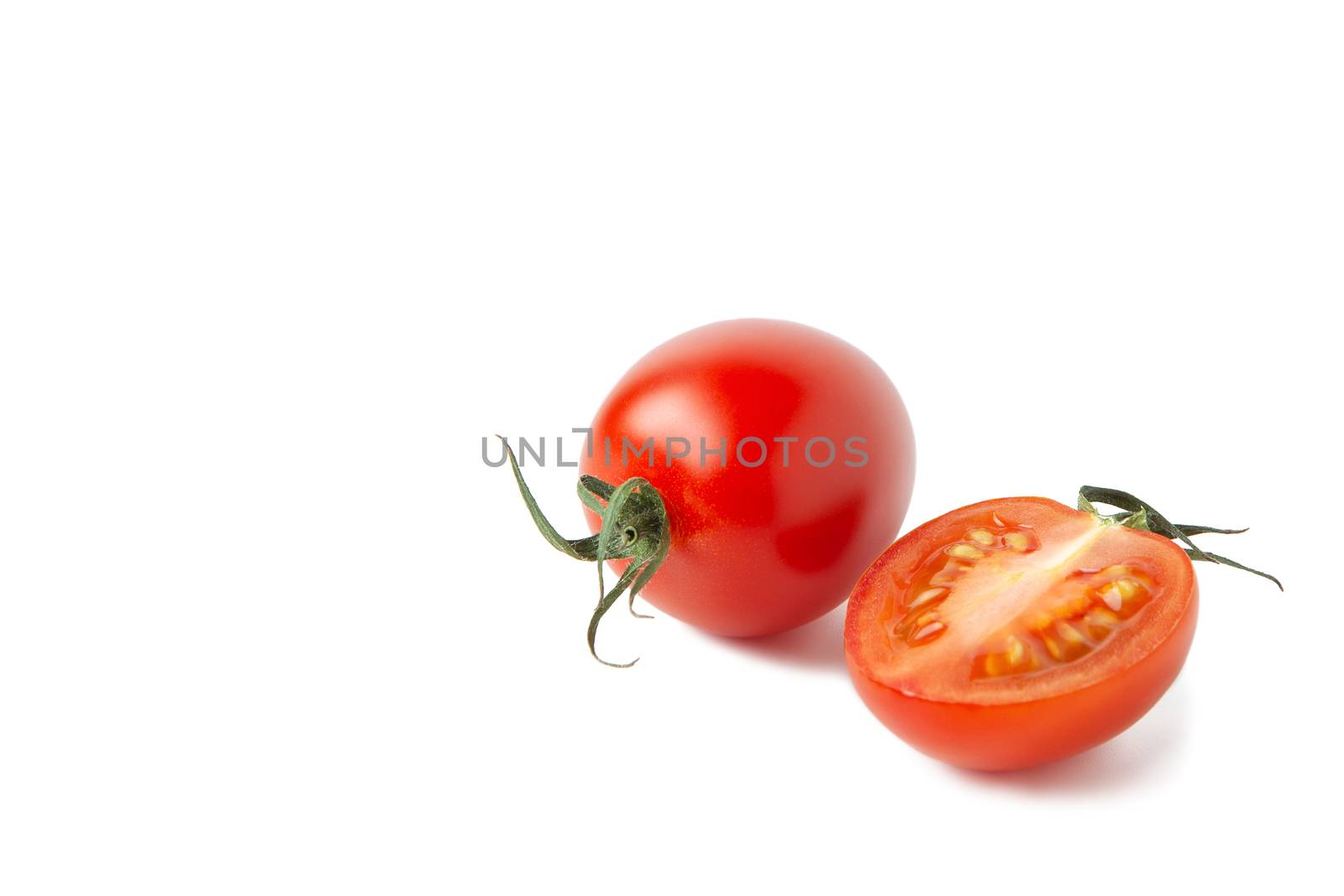 Whole fresh red cherry tomato with leaves, half fetus with small shadow isolated on white background. Macro, flat lay. Horizontal, close-up. Healthy eating, farmer's product, raw food, keto diet.