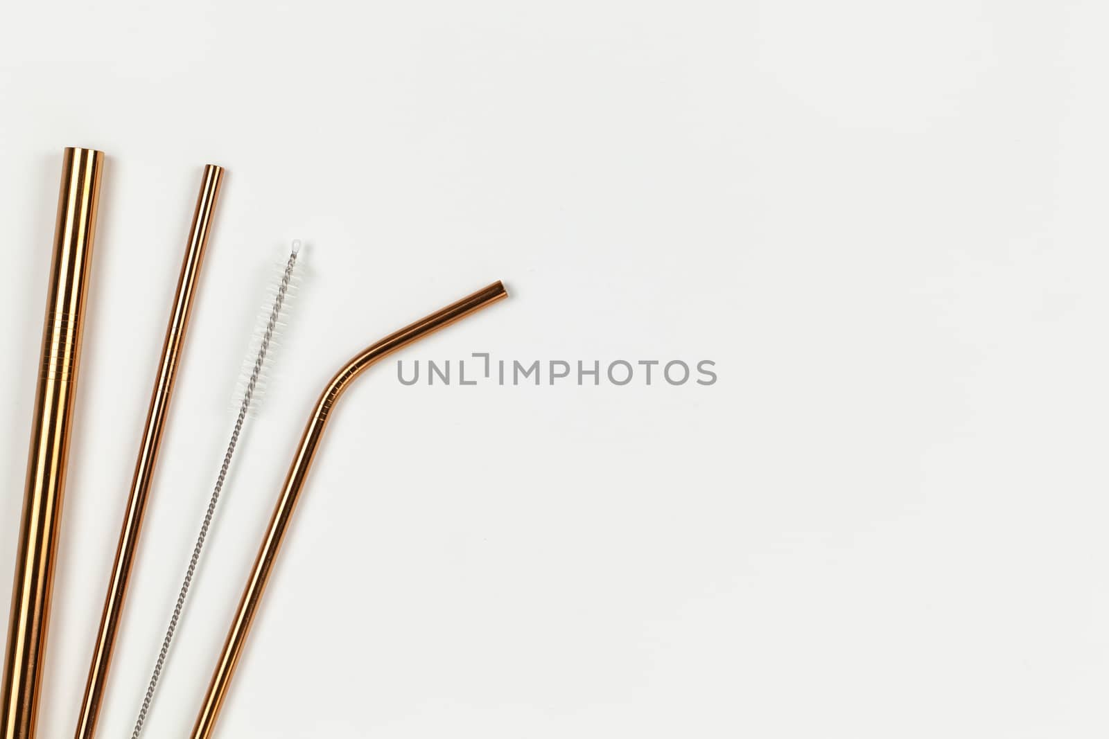 Tubes from environmental reusable metal opposition to plastic disposable tubes. Alternative to disposable tableware concept. White background. Horizontal. Copy space. Flat lay, closeup, top veiw.