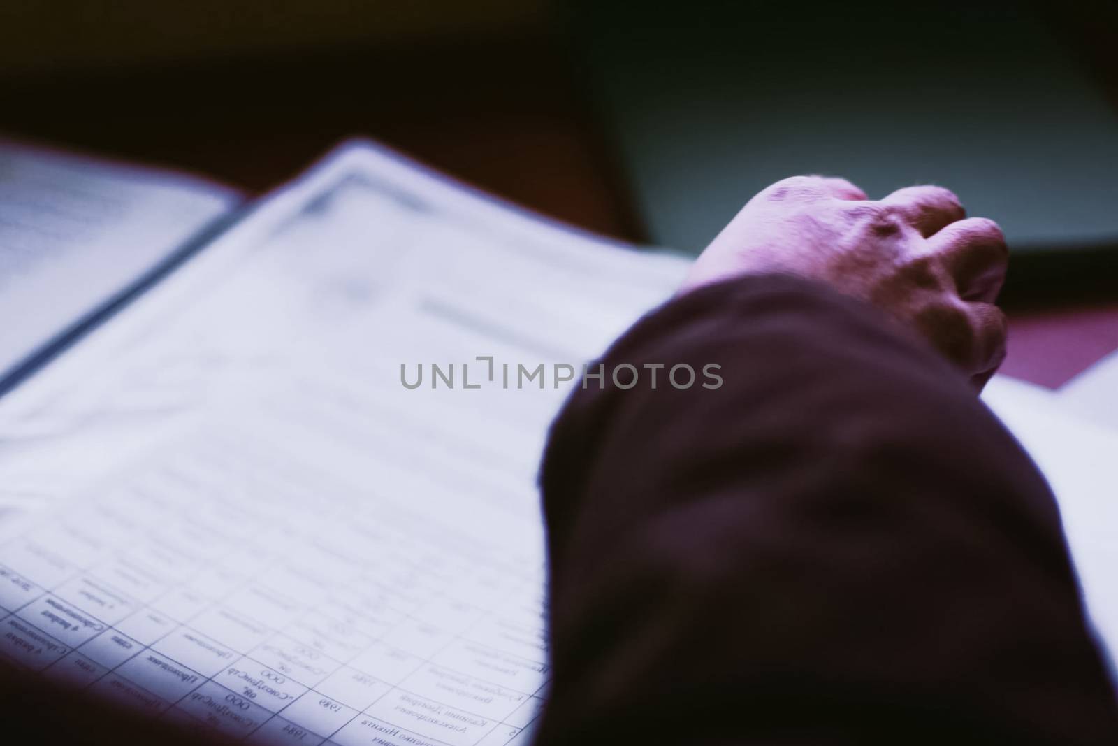 Scrolling through a sheet of paper. Hands of a man over a sheet of paper