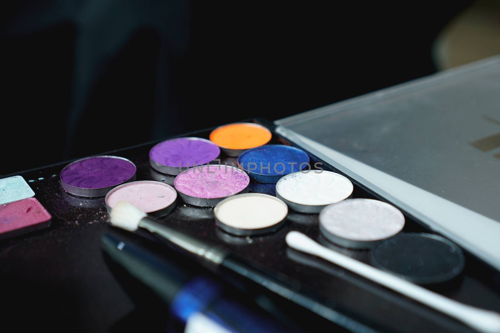 Use palette of shadows for makeup on a blurred background, closeup