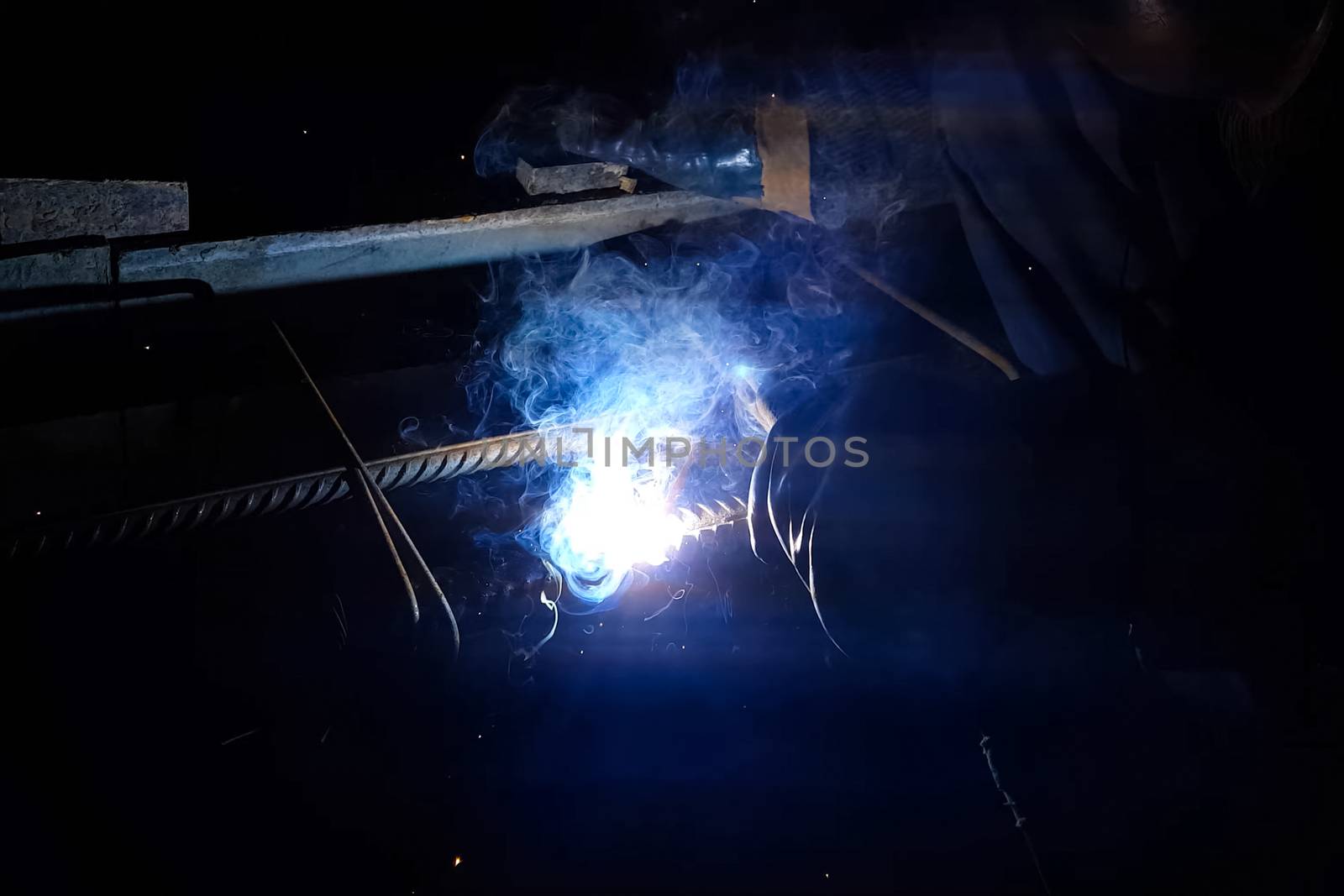 Welding of steel reinforcement. Sparks and light from welding. Electric welding.