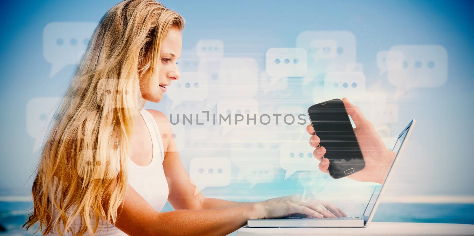 Composite image of pretty blonde using her laptop at the beach with hand holding phone