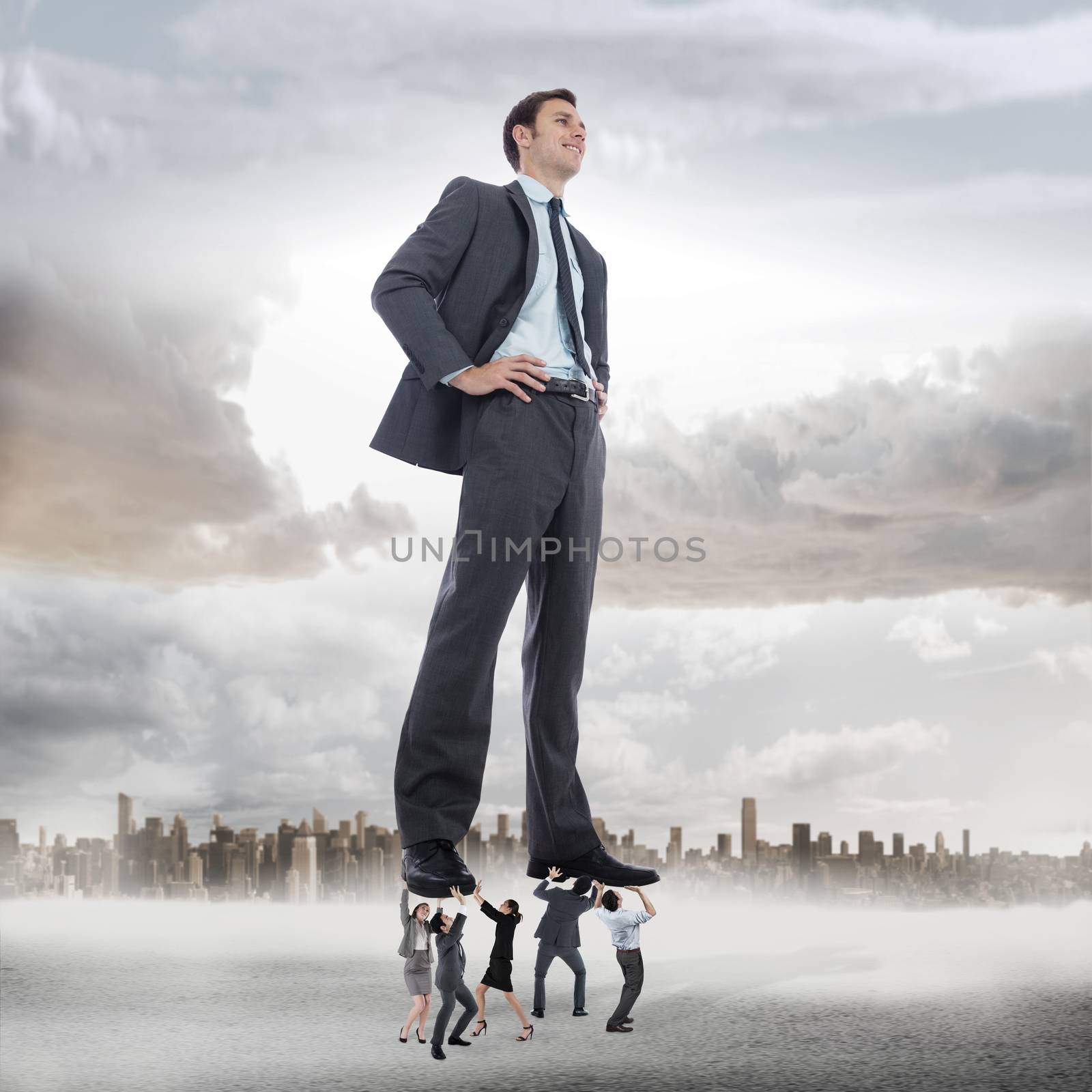 Business team supporting boss against large city on the horizon