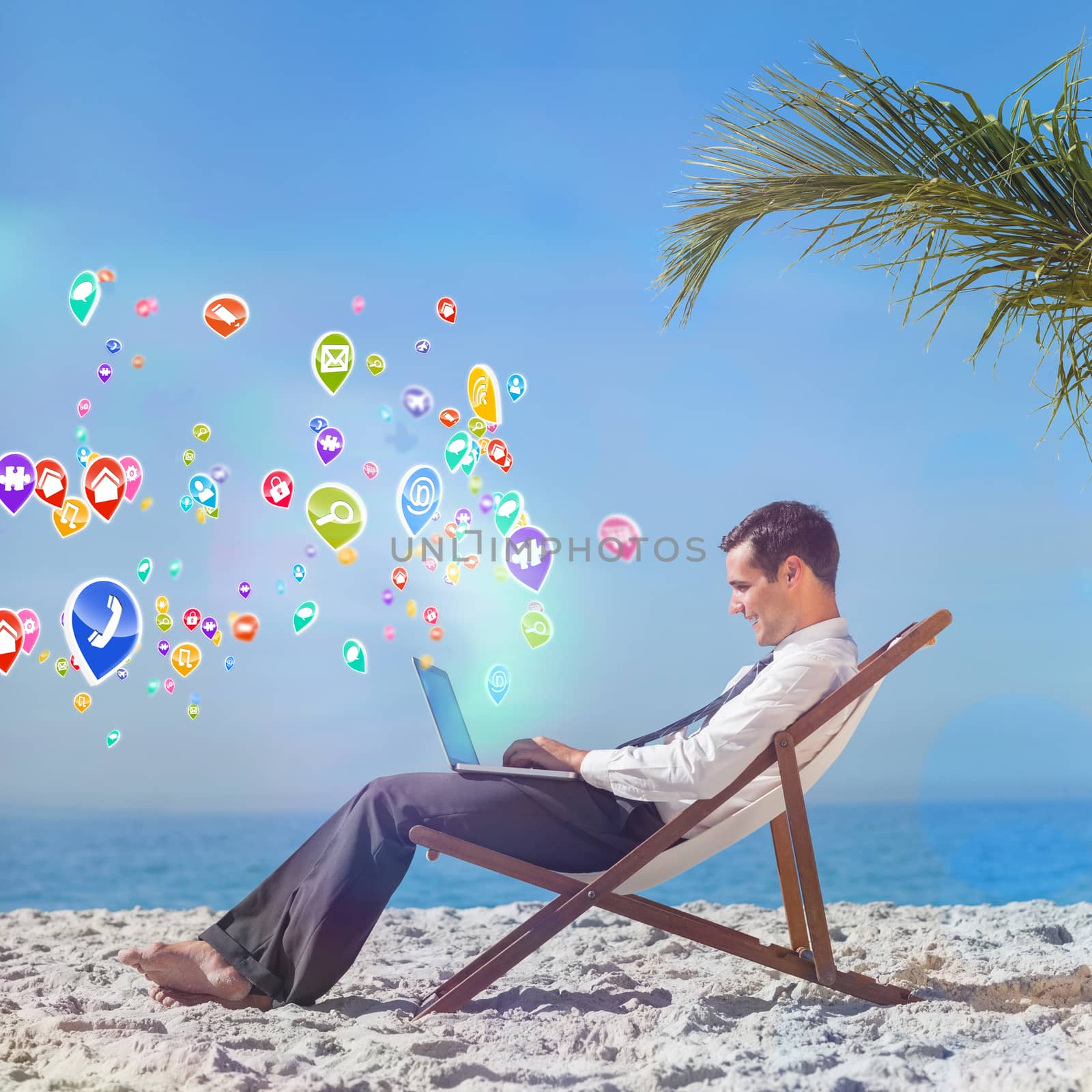 Young businessman on his beach chair using his laptop with colourful computer applications