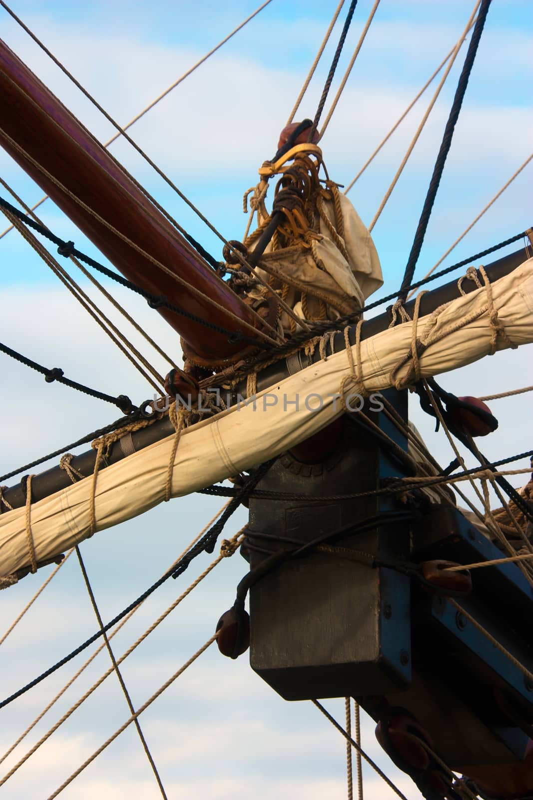 Vertical shot of bowsprit, rigging and furled sail of an old sailing ship