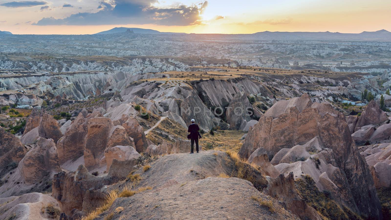 Professional photographer standing on mountain landscape of Cappadocia, Turkey.