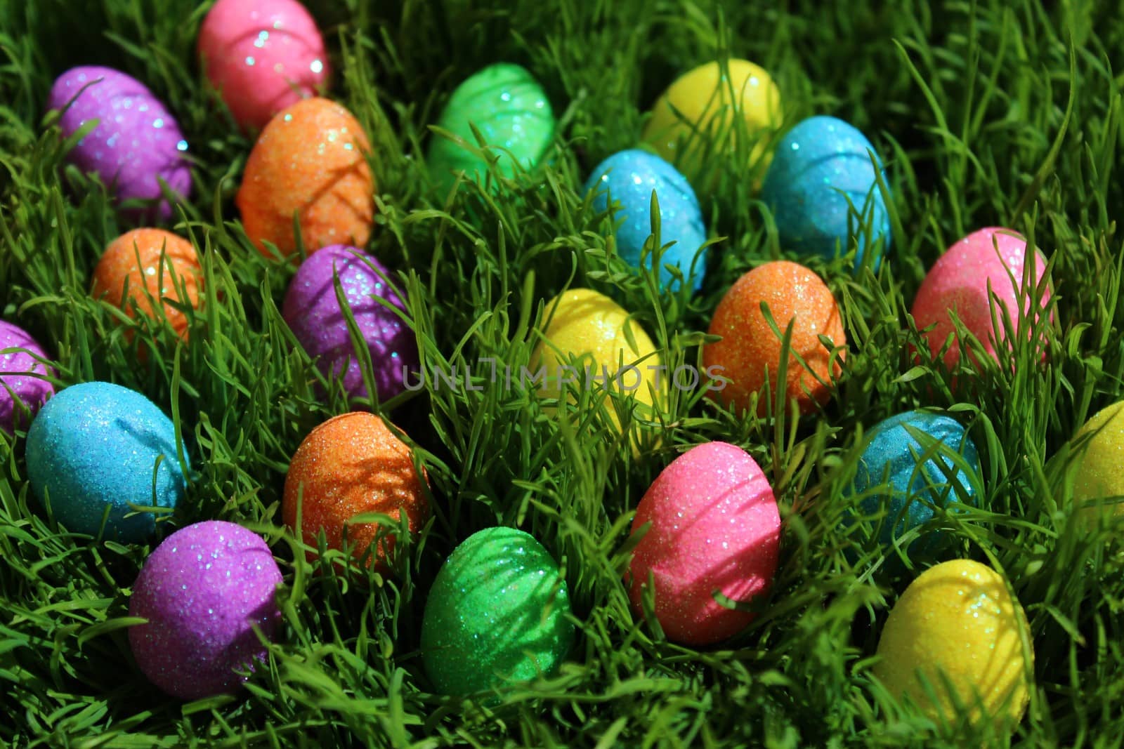 The picture shows colourful eastereggs in eastergrass