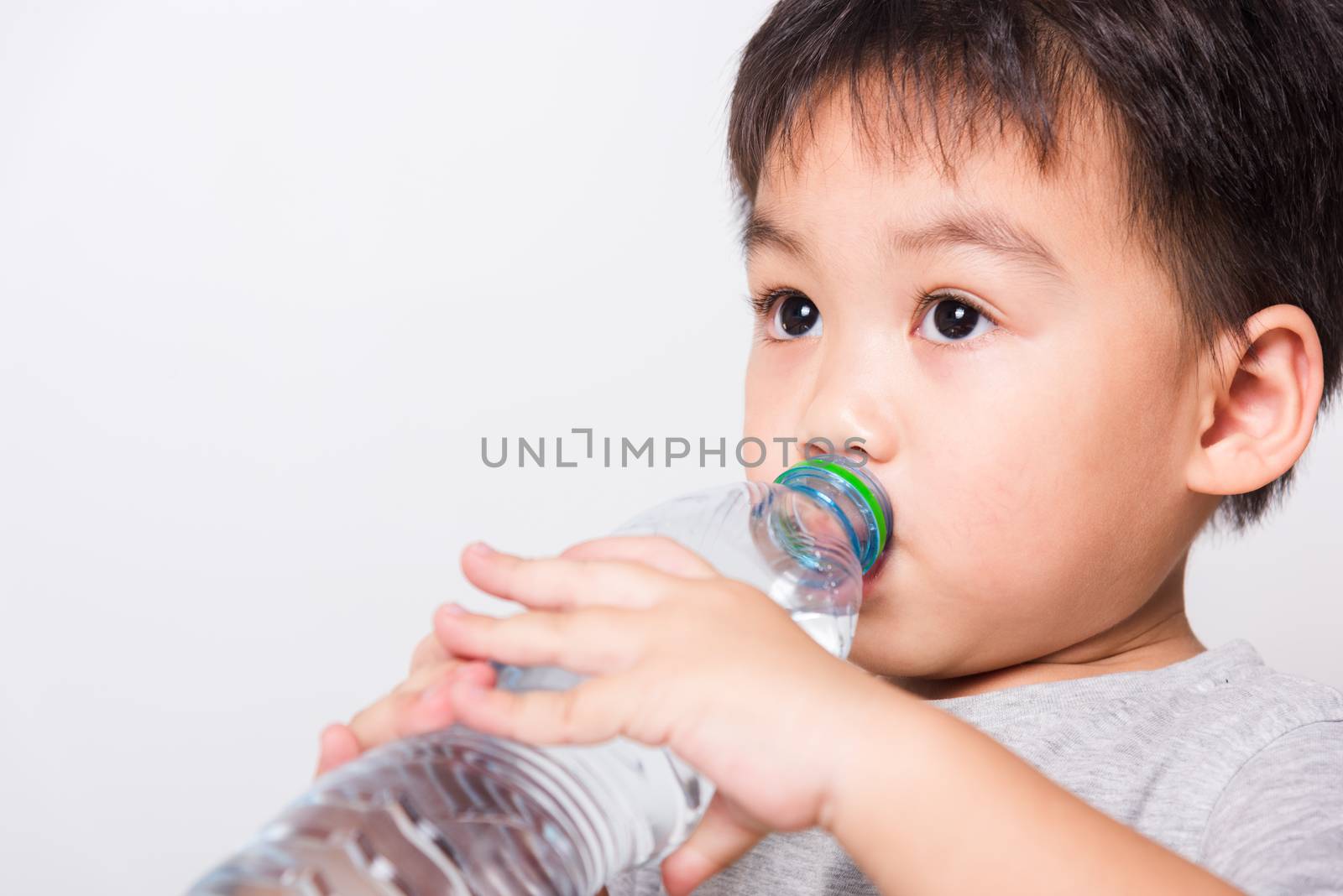 Closeup Asian face, Little children boy drinking water from Plastic bottle on white background with copy space, health medical care