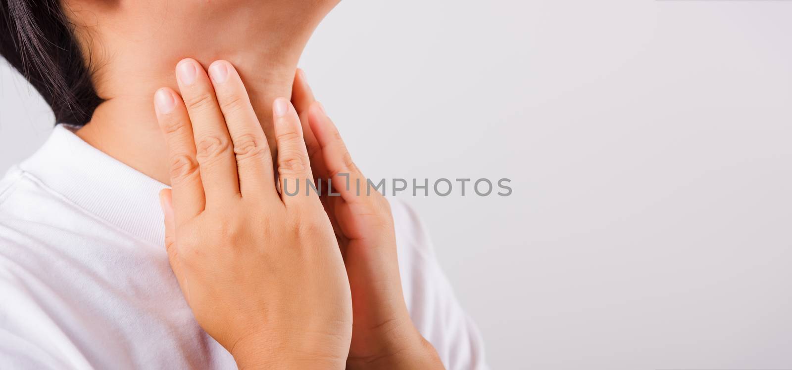 Asian beautiful woman Sore Throat or thyroid gland problem her useing Hand Touching Ill Neck on white background with copy space, Medical and Healthcare concept