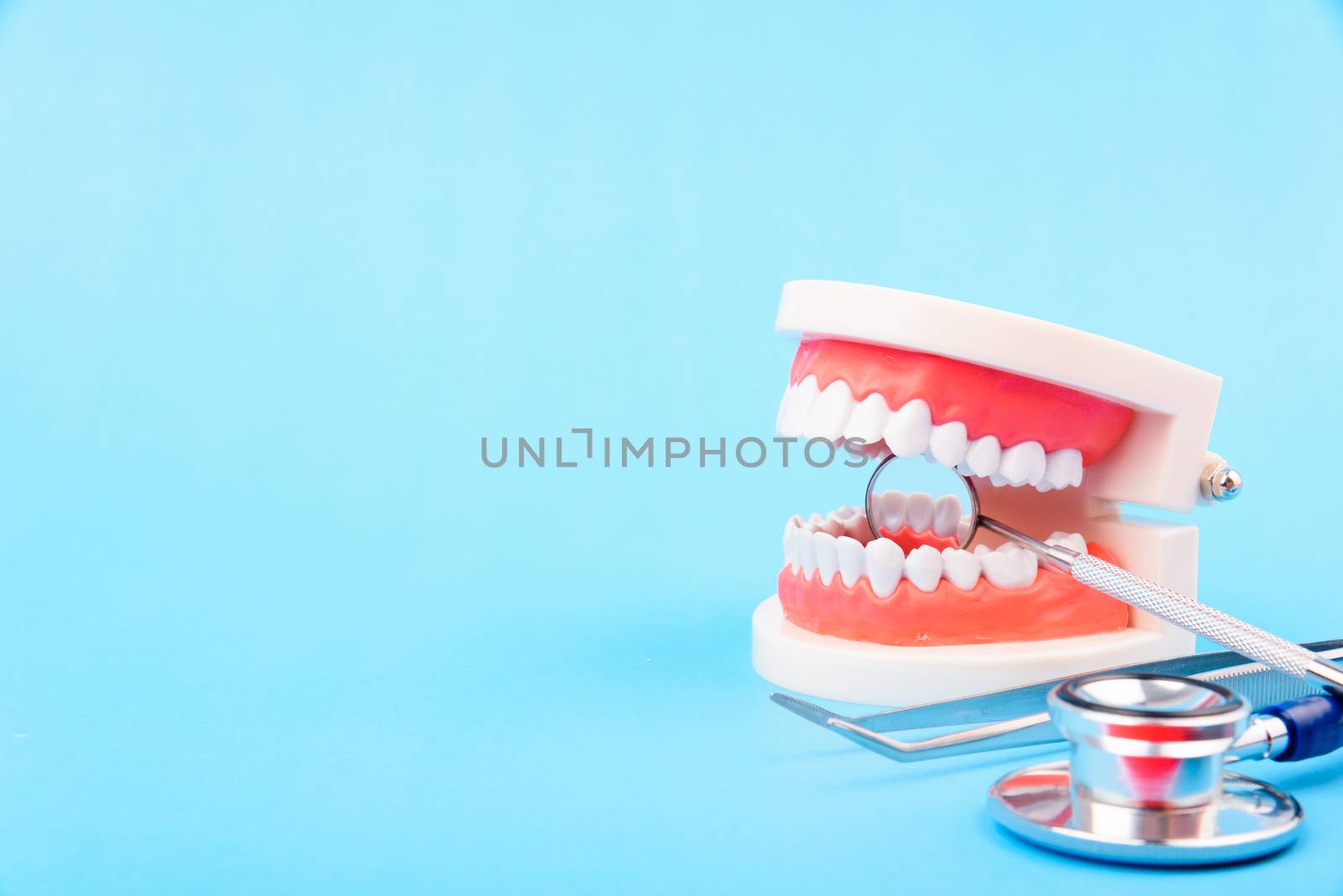 Dental Hygiene Health Concept, White tooth and Dentist tools for dental care on blue background