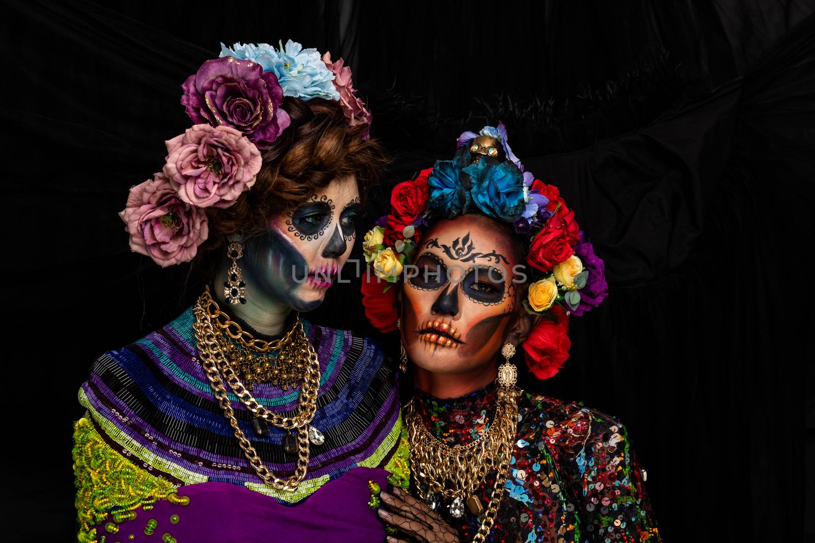 Closeup portrait of a woman with a sugar skull makeup dressed with flower crown. Halloween concept