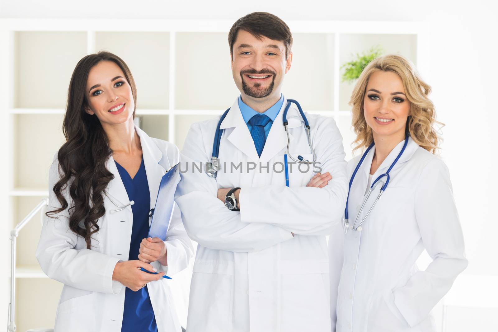 Smiling medical doctors with stethoscopes in medical clinic office