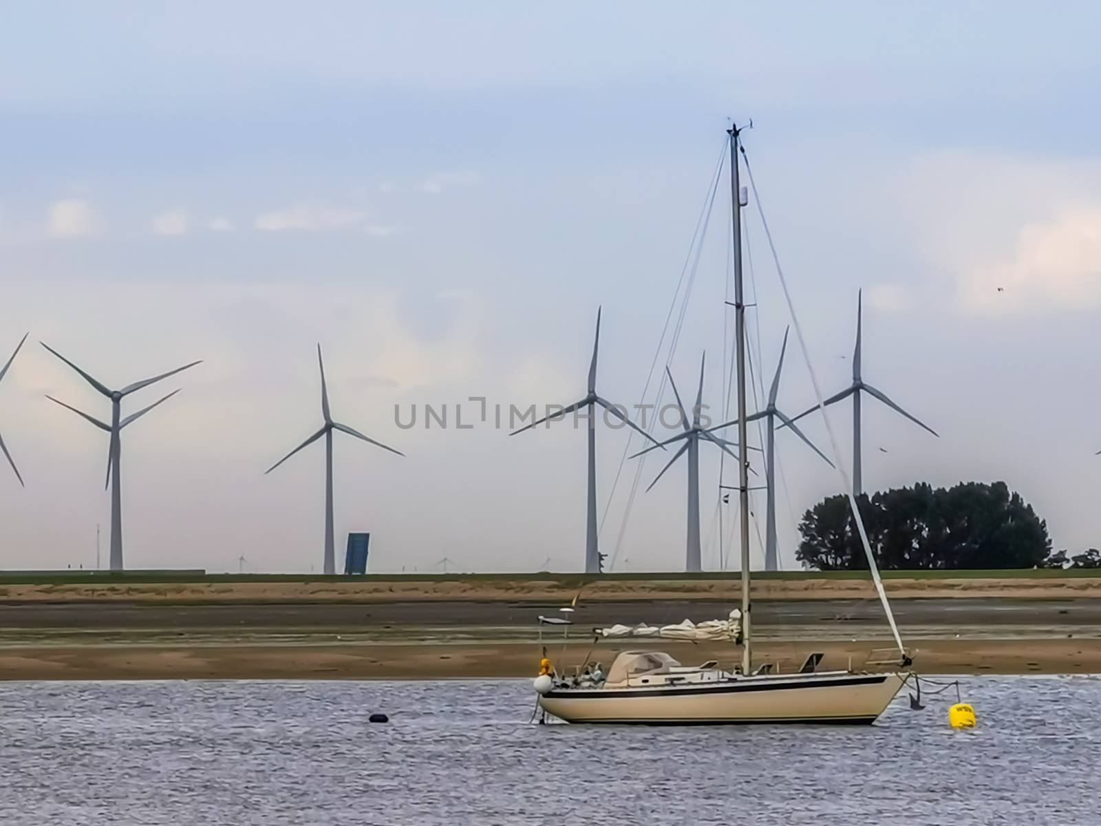 ship sailing on the ocean of Sint annaland, Landscape with windmills, Zeeland, The Netherlands by charlottebleijenberg