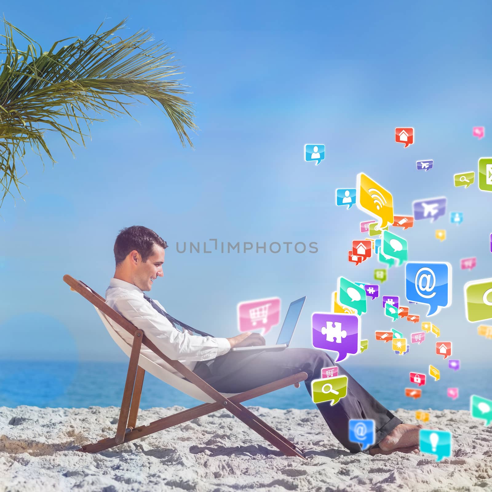 Young businessman on his beach chair using his laptop with colourful computer applications