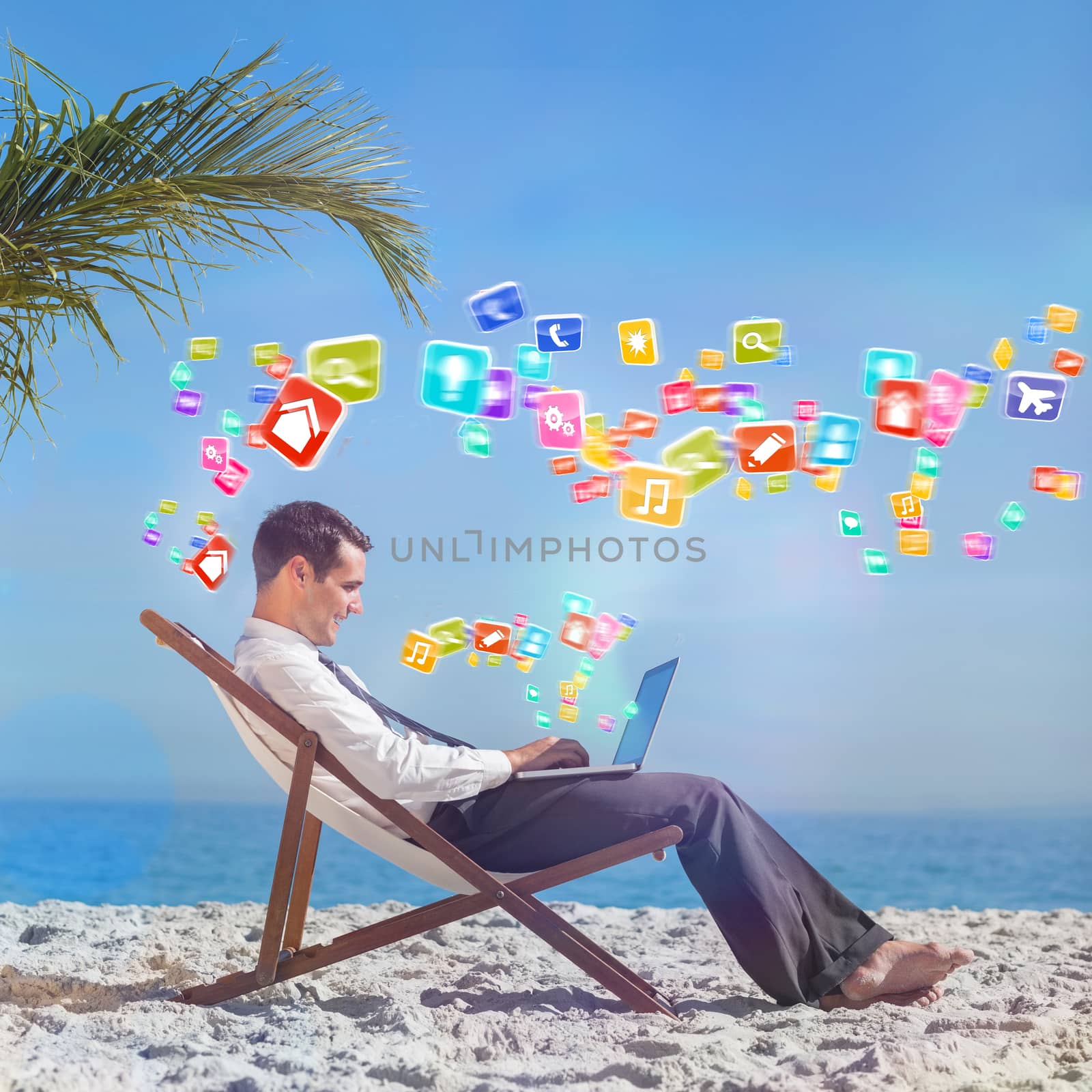 Young businessman on his beach chair using his laptop with colourful computer applications