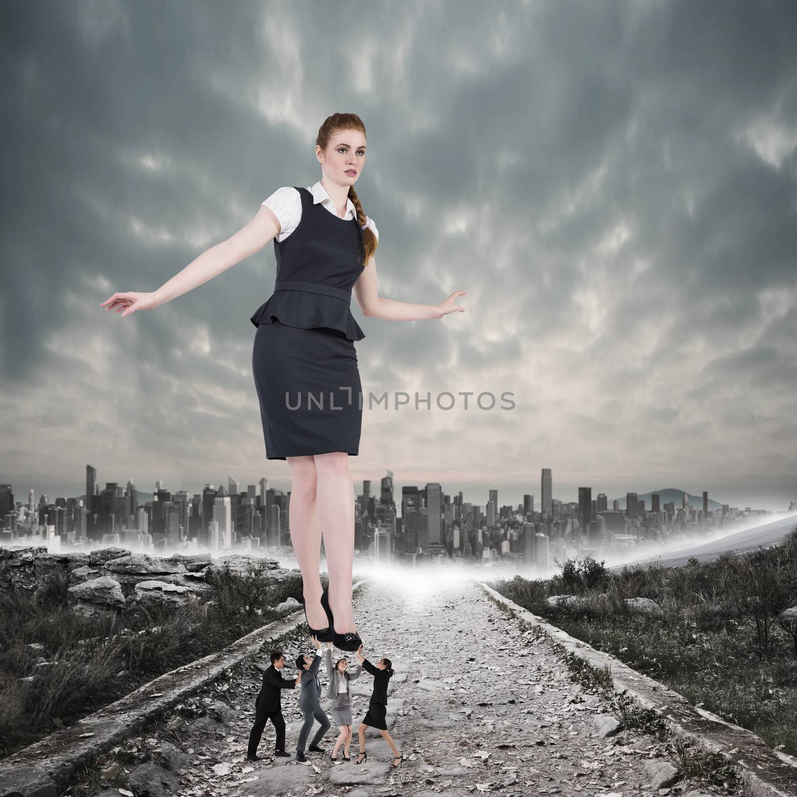 Business team supporting boss against stony path leading to large city on the horizon