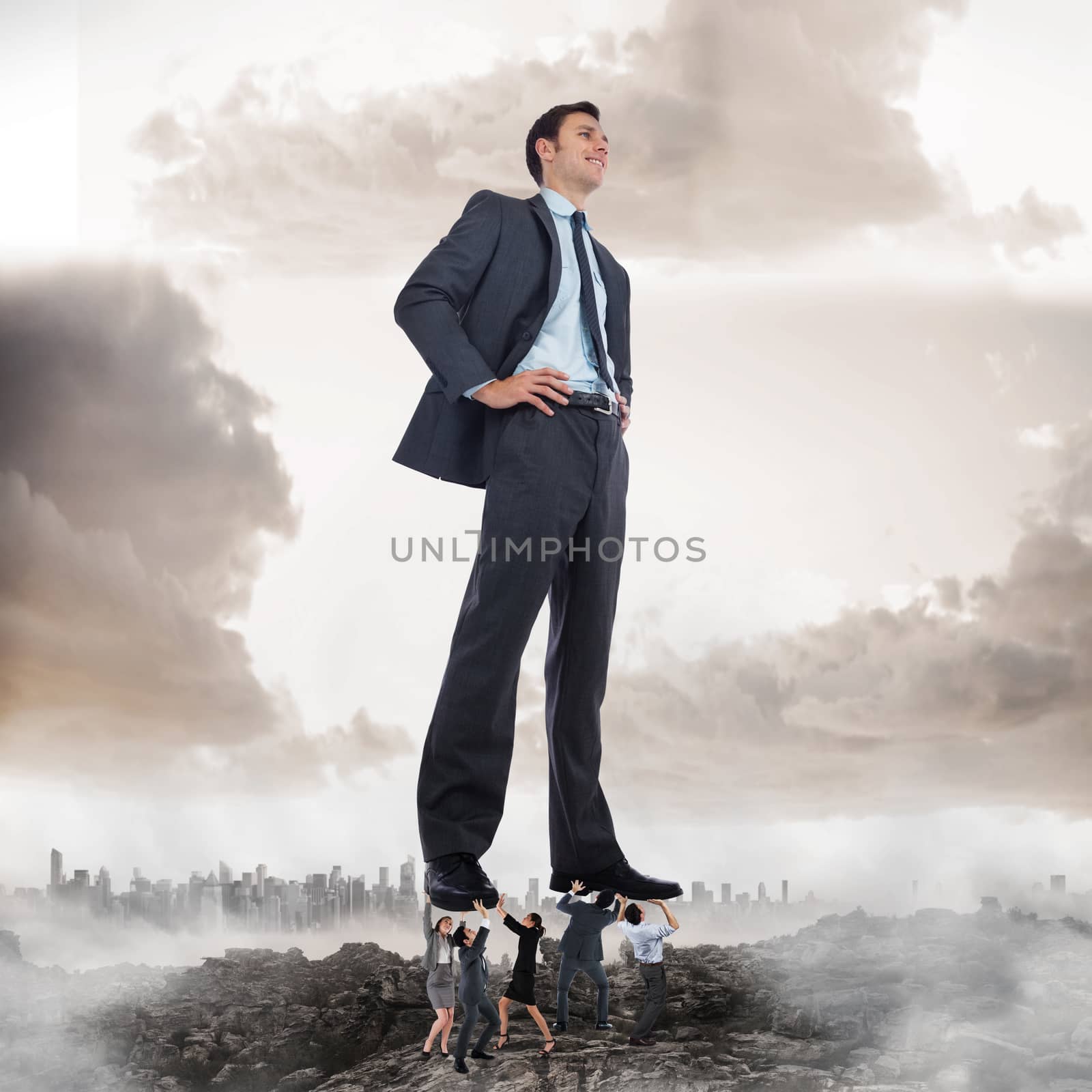 Composite image of business team supporting boss against misty landscape