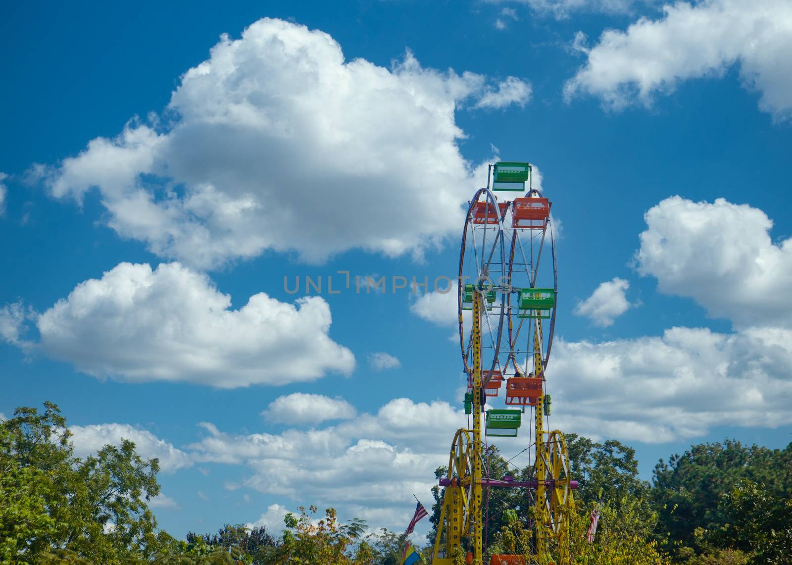 A colorful ferris wheel at a fair against a blue sky