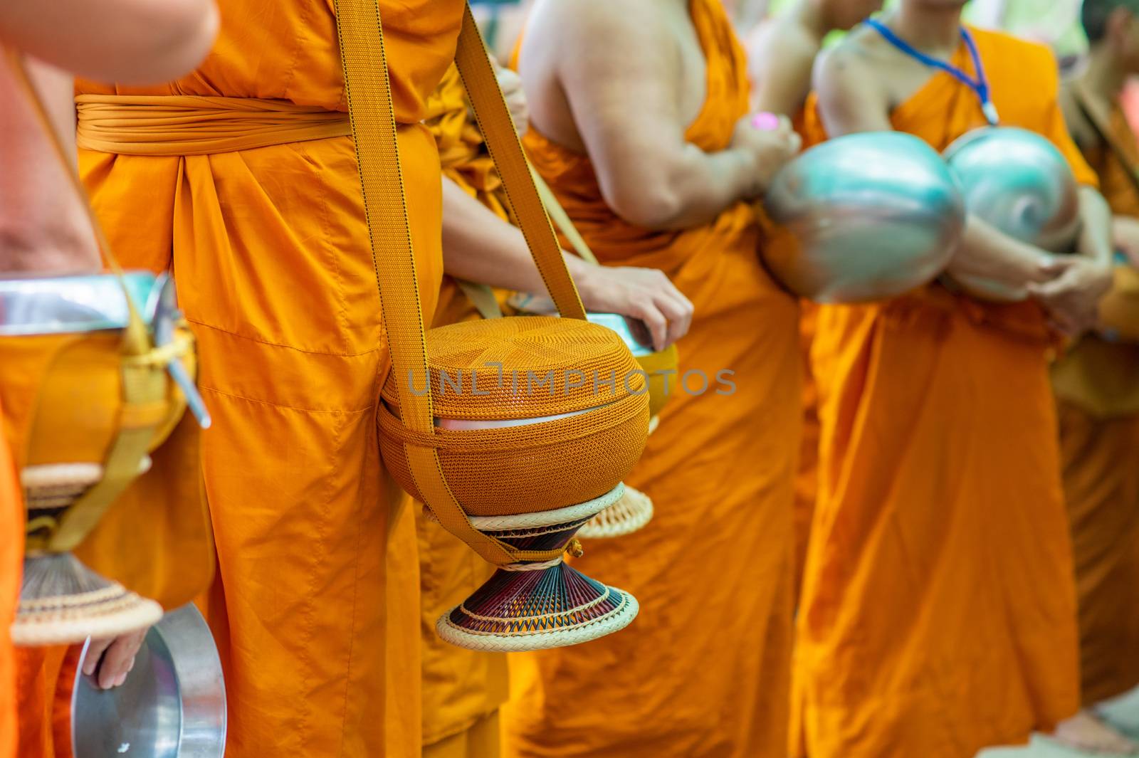 Alms round The yellow robes of monks walk on alms round as a Buddhist activity. by sarayut_thaneerat