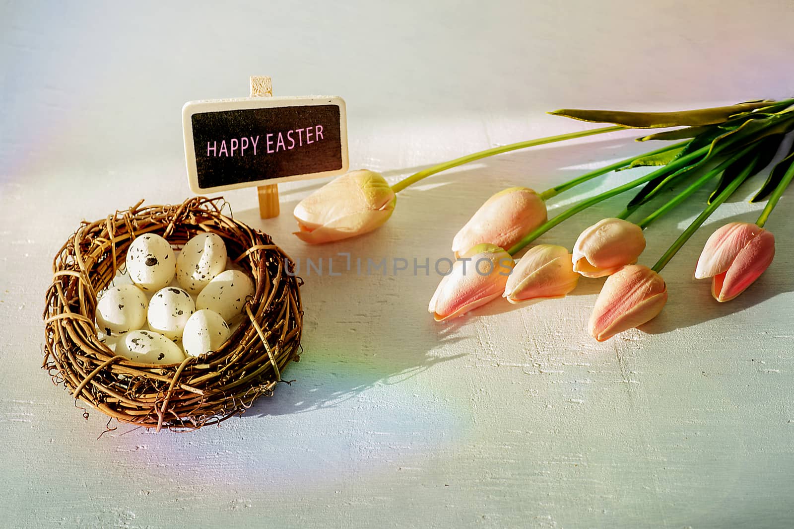 Easter eggs and tulips on wooden planks.