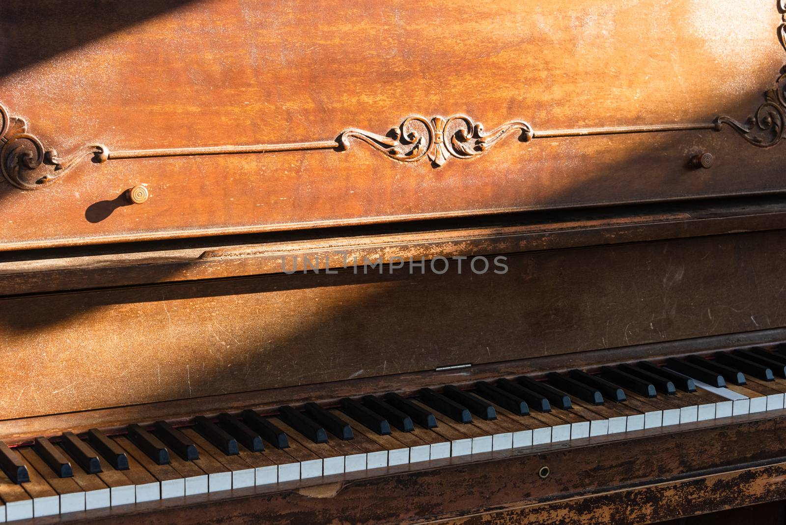 Open keyboard of street piano in sunlight ray