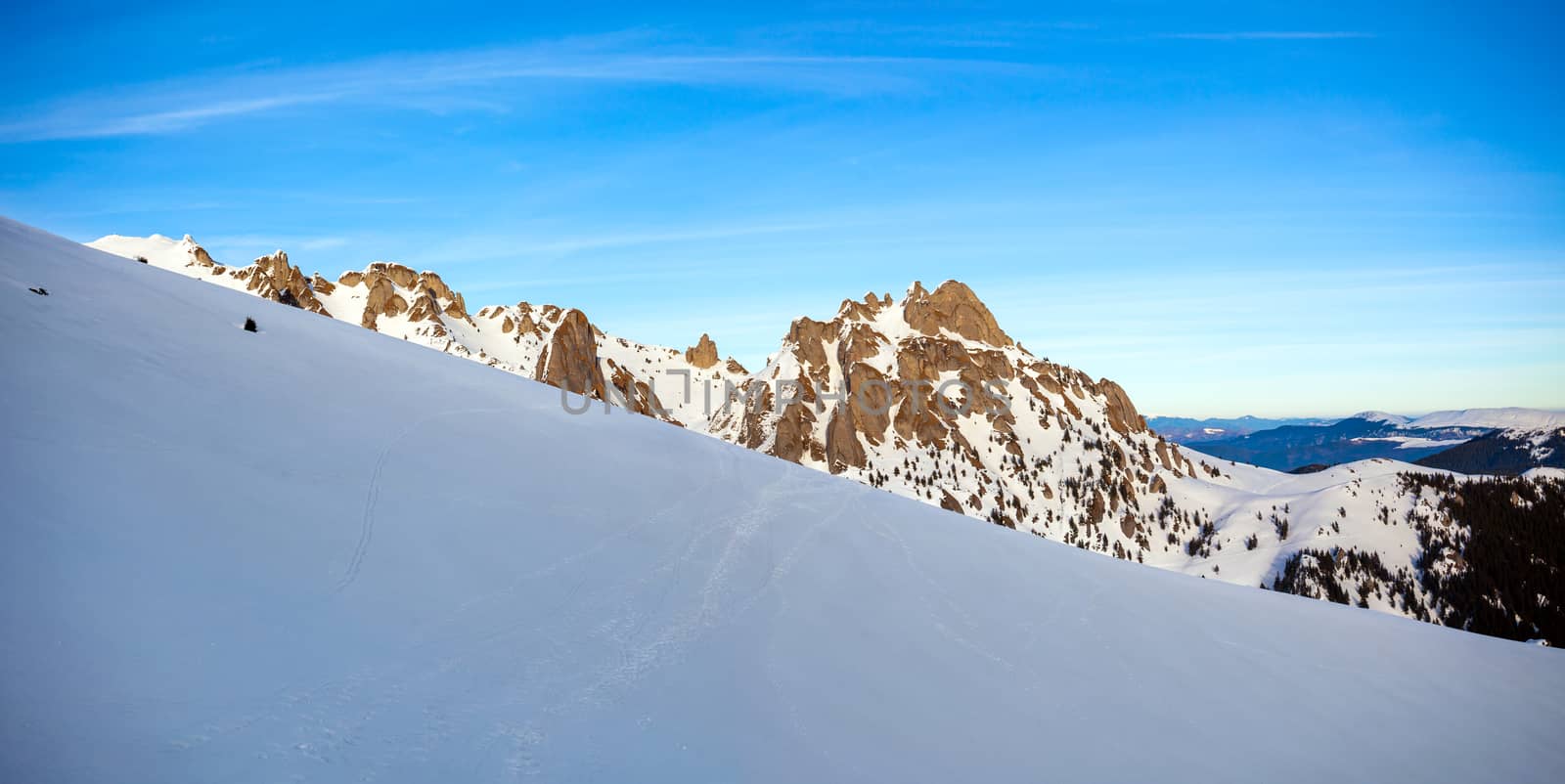 Panoramic view of Mount Ciucas peak at a sunset on winter by PixAchi