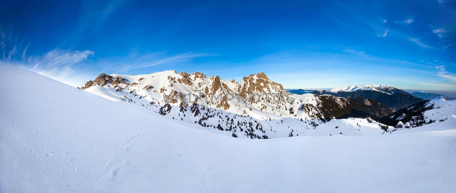 Panoramic view of Mount Ciucas peak at a sunset on winter, part of Romanian Carpathian Range