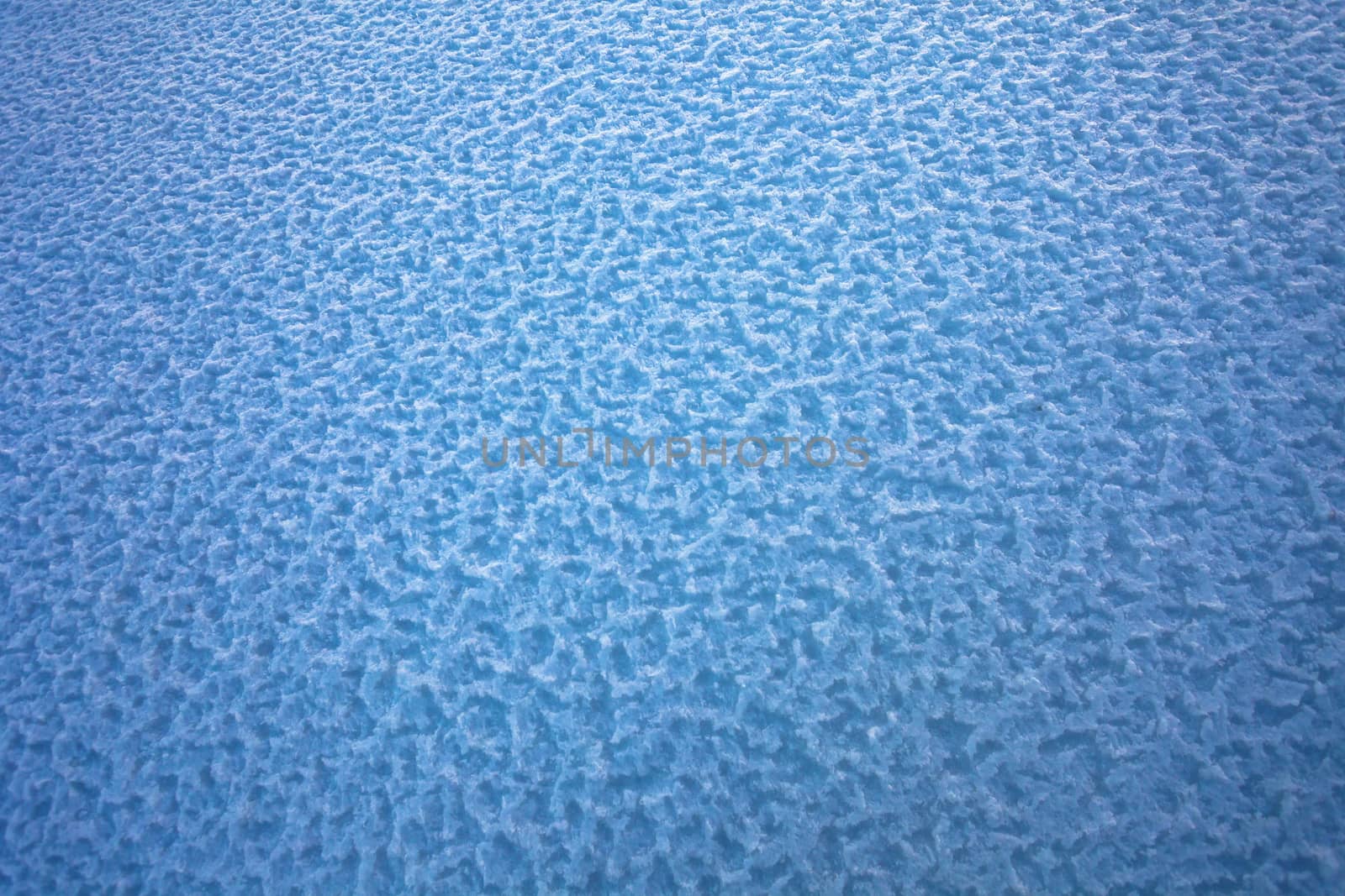 Background of frozen snow texture in blue tone field, in the winter season