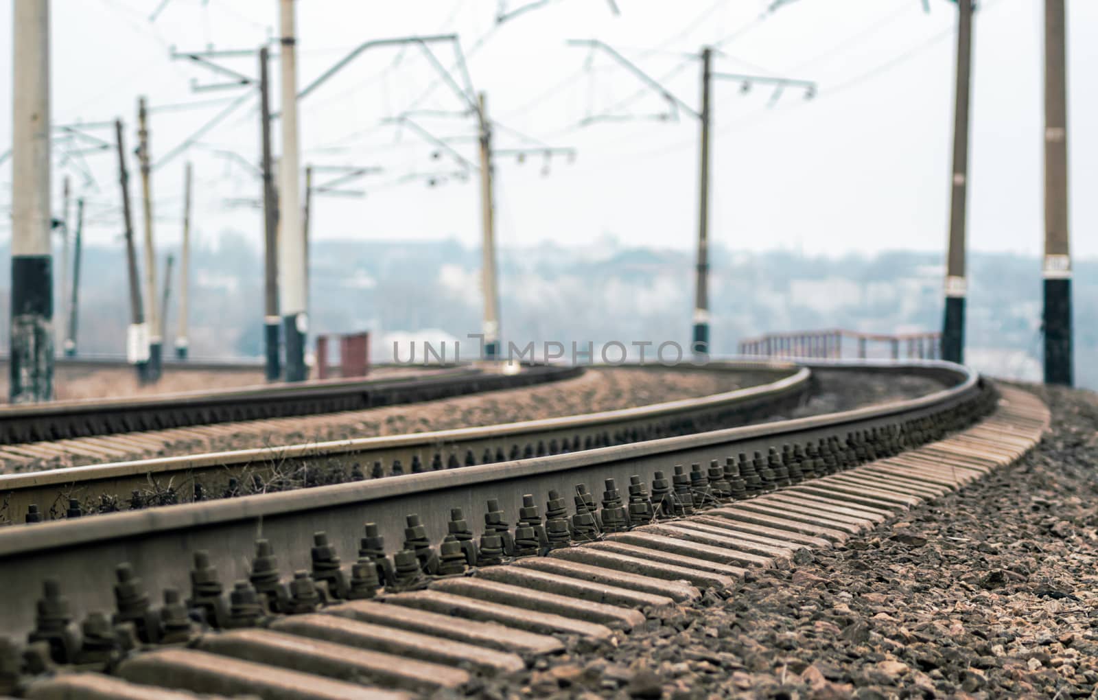 old railroad rails and poles with wires without a train without people