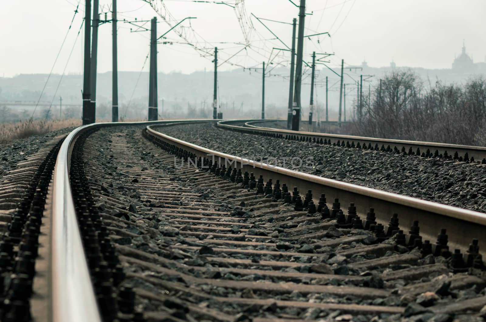 old railroad rails and poles with wires without a train without people