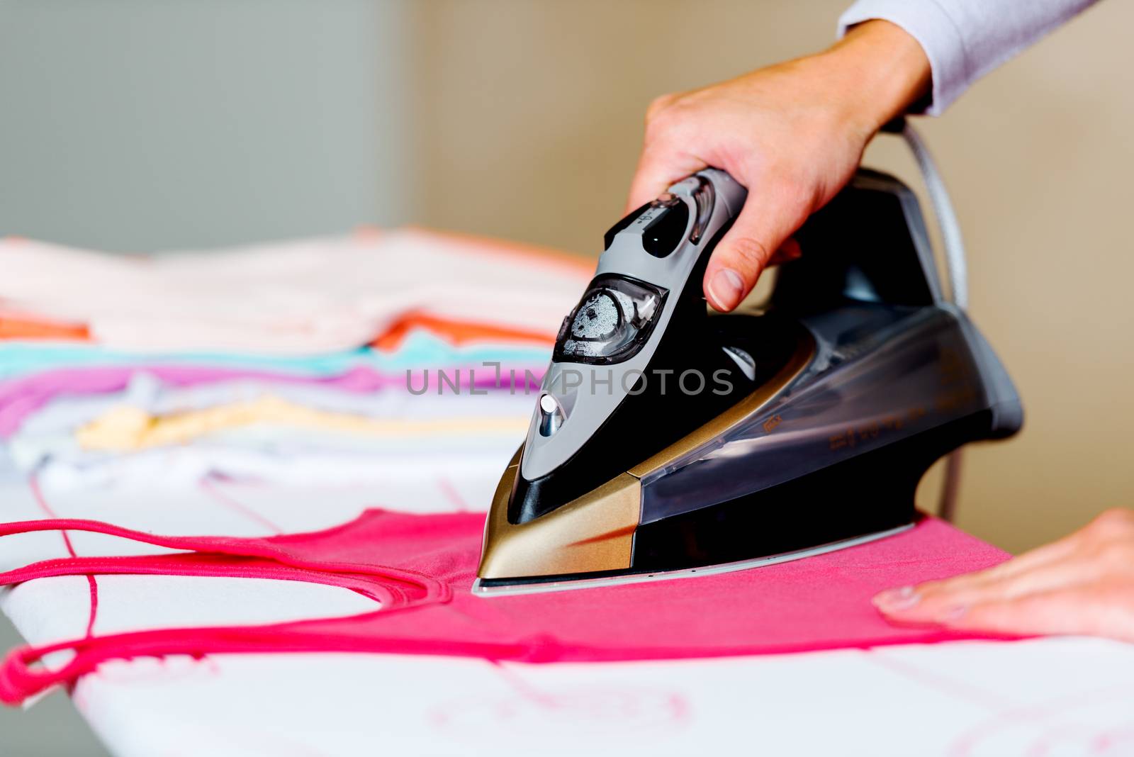 Female hand ironing clothes on board by Nanisimova