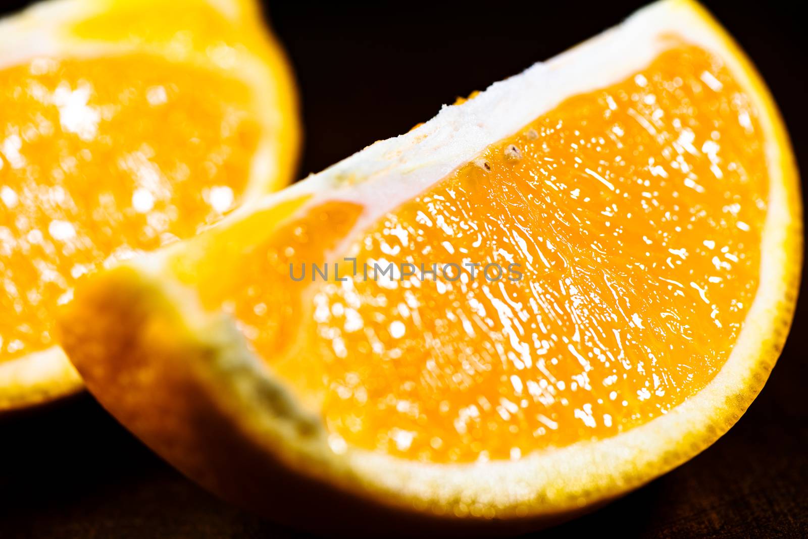 Sliced close up oranges on dark background with selective focus