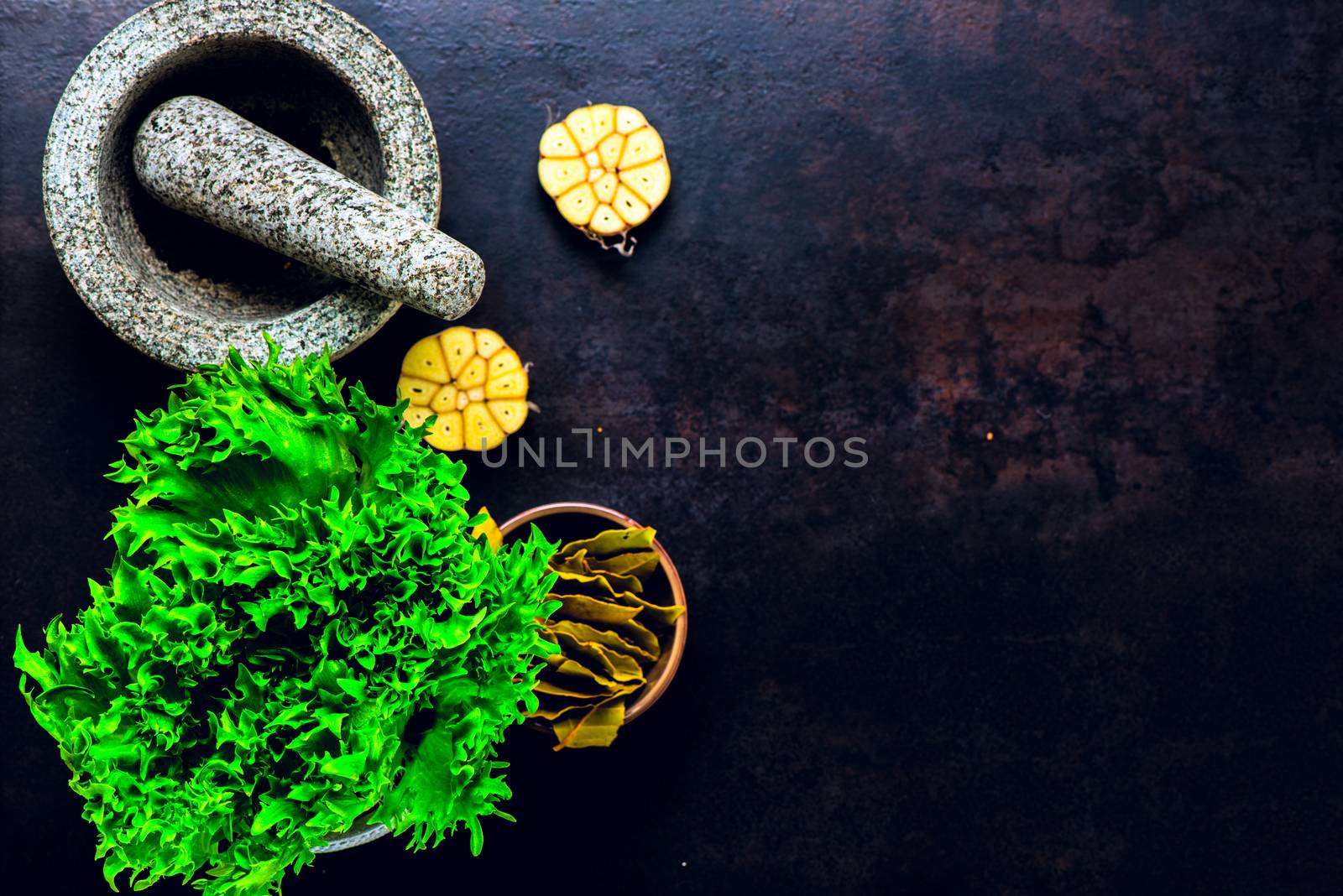 Stone mortar bowl and pestle on dark stone surface by Nanisimova