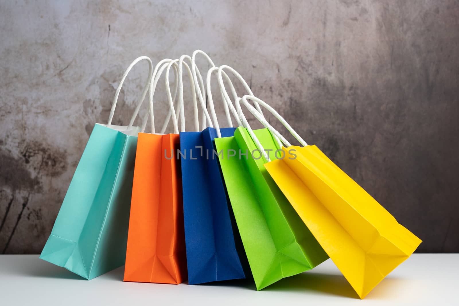 Five colorful gift or shopping bags against grunge background