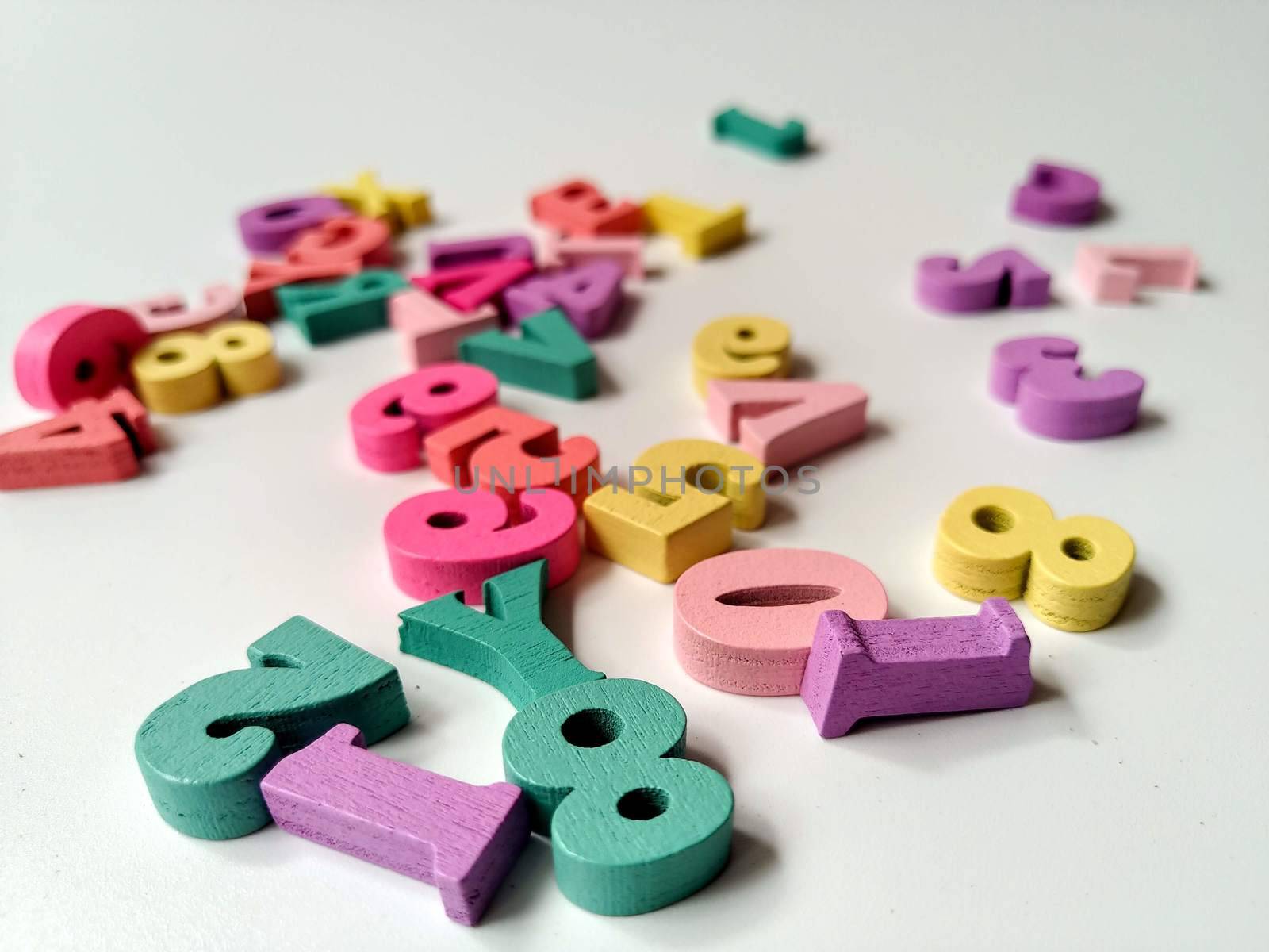 Children's colored letters placed on a white background.