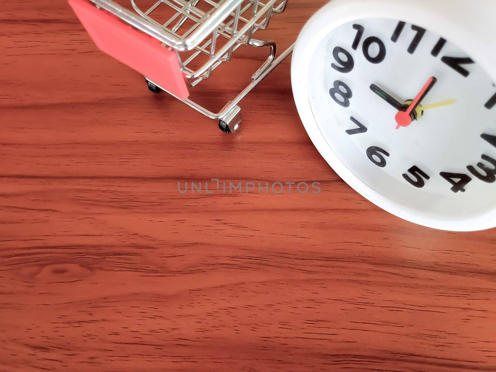 A white clock and a mini cart placed on a brown wooden table. Trading Business