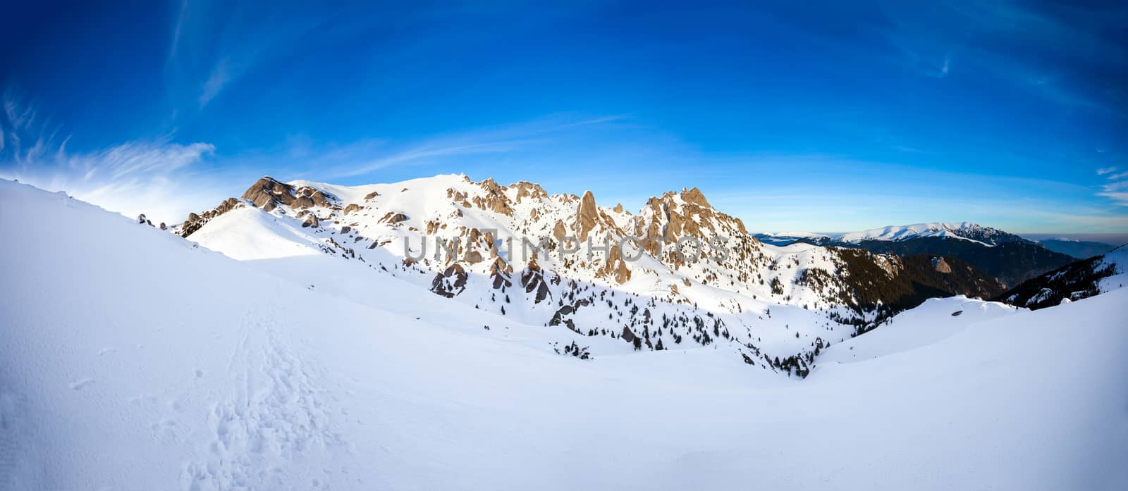 Panoramic view of Mount Ciucas peak at a sunset on winter, part of Romanian Carpathian Range