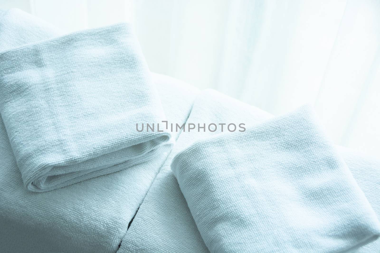 white towel on white mattress fabric, soft light in the morning.