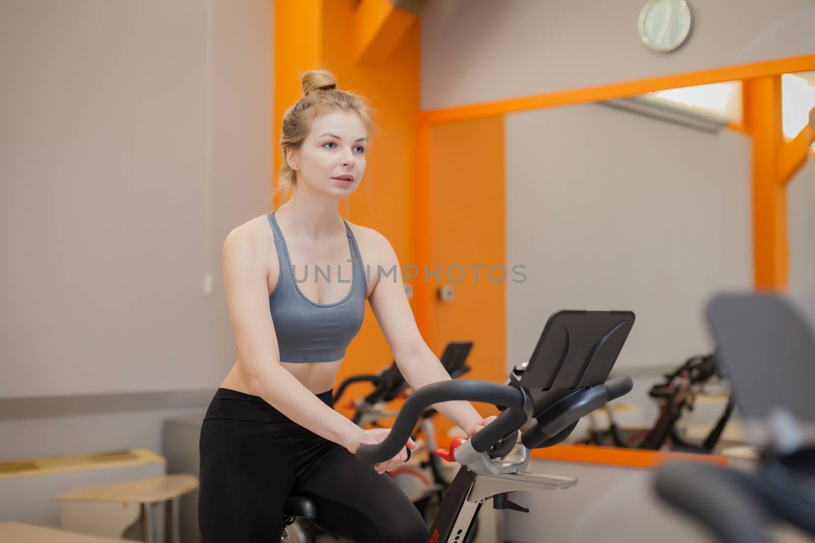 Woman doing cardio workout biking training in indoors gym by Angel_a