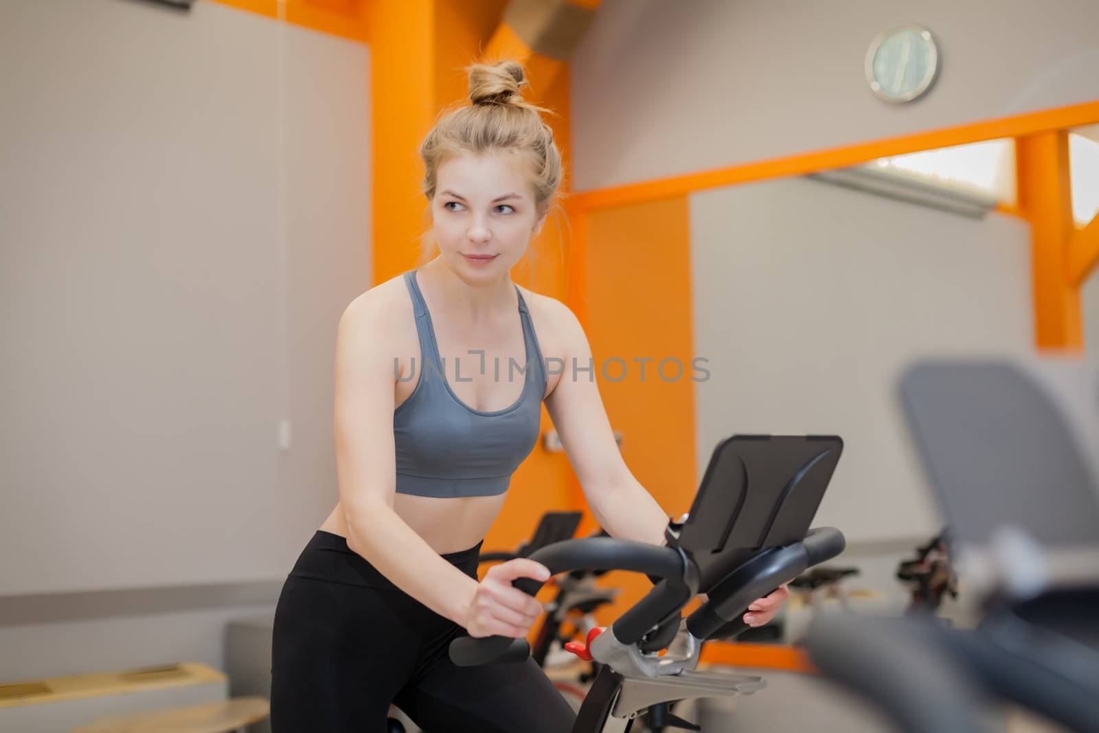 Woman doing cardio workout biking training in indoors gym by Angel_a