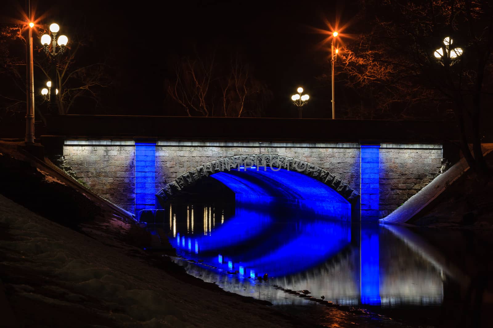 One of the pedestrian bridges spanning the city canal in Riga, capital of Latvia, is illuminated at night.