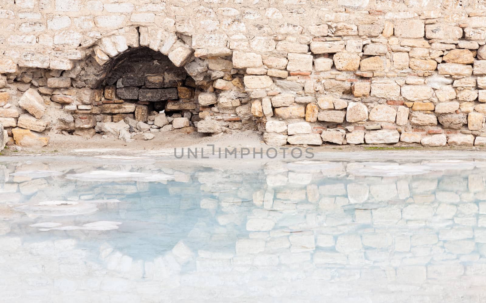 The view across a hot spring towards a ruined building in Hierapolis, southwestern Turkey.  The site is a UNESCO World Heritage Site.