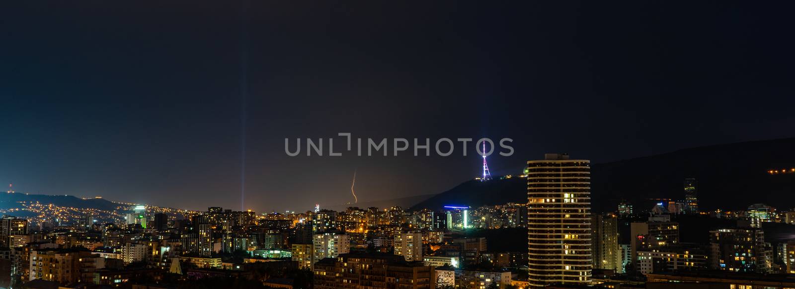 Storm and flashlight over the night sky over Tbilisi's downtown