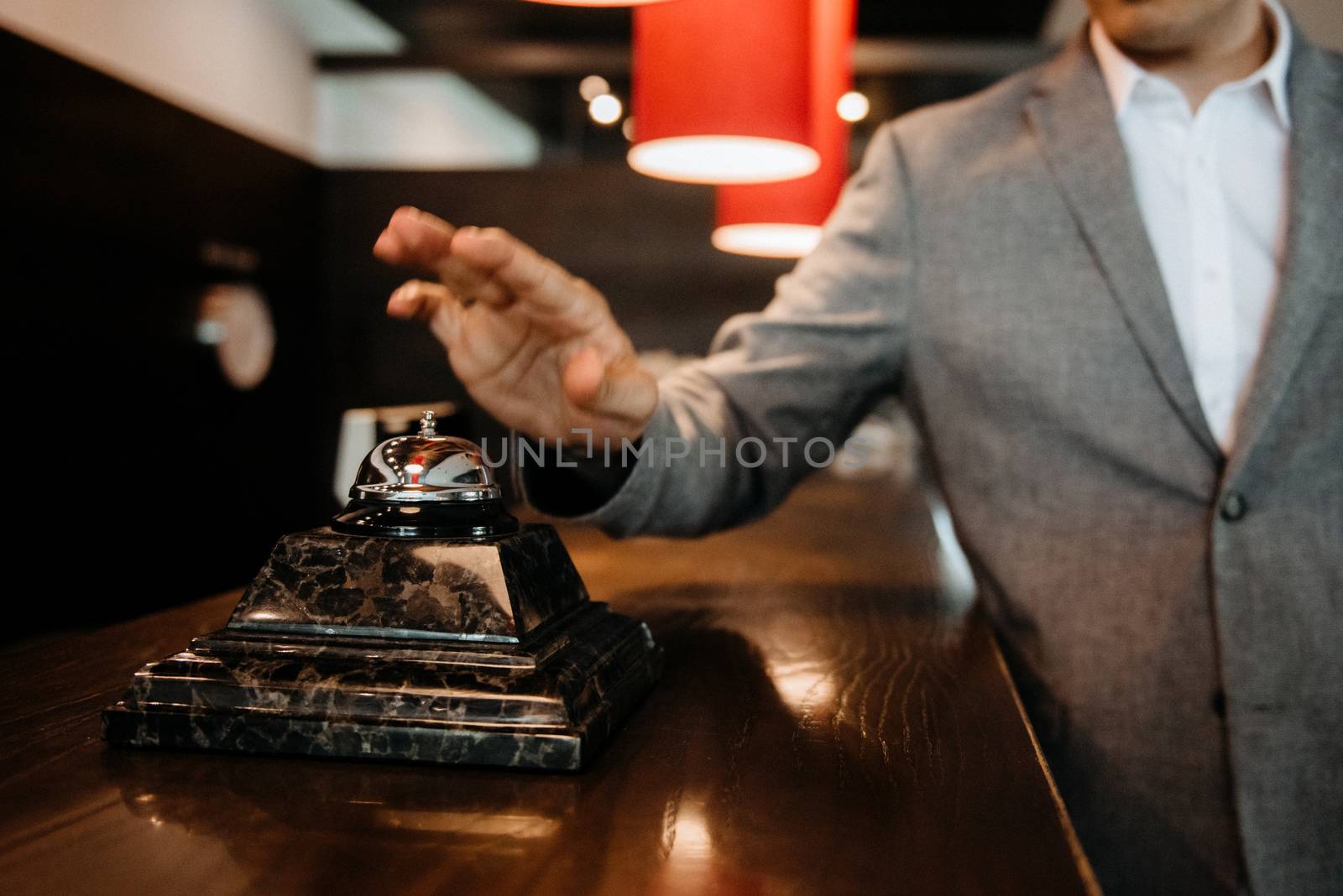 the guy clicks on the bell at the reception of the hotel