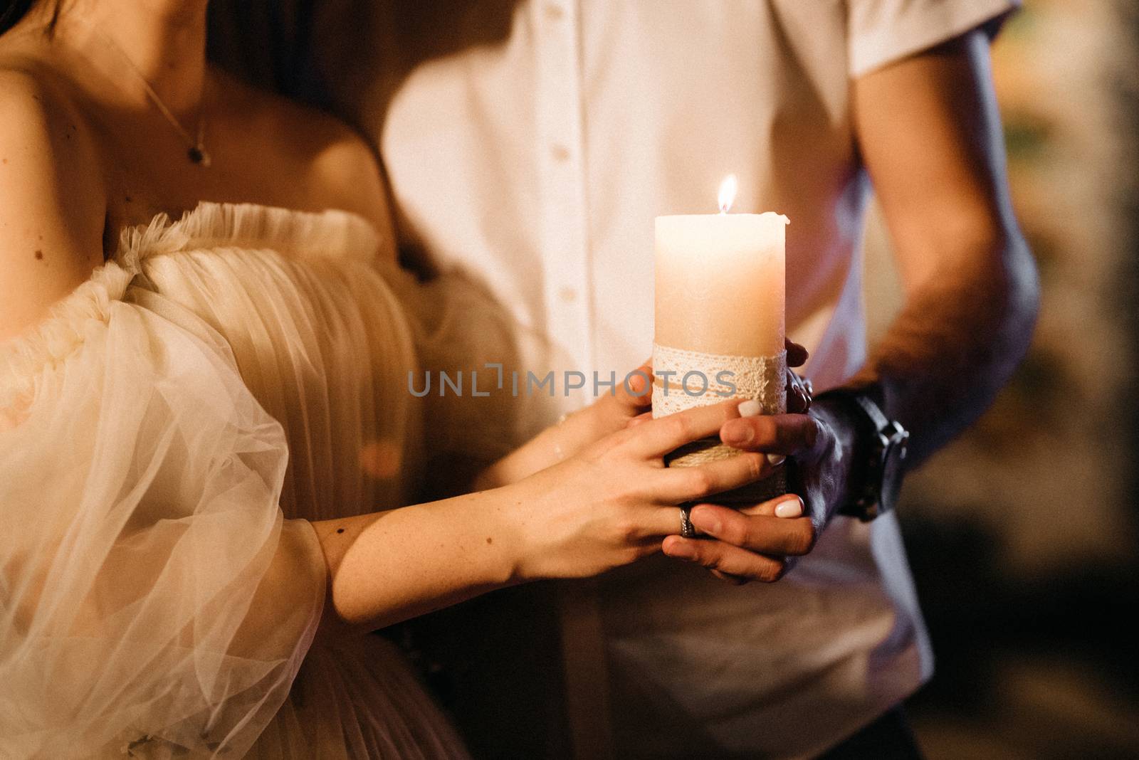 the bride and groom held candle in hands by Andreua