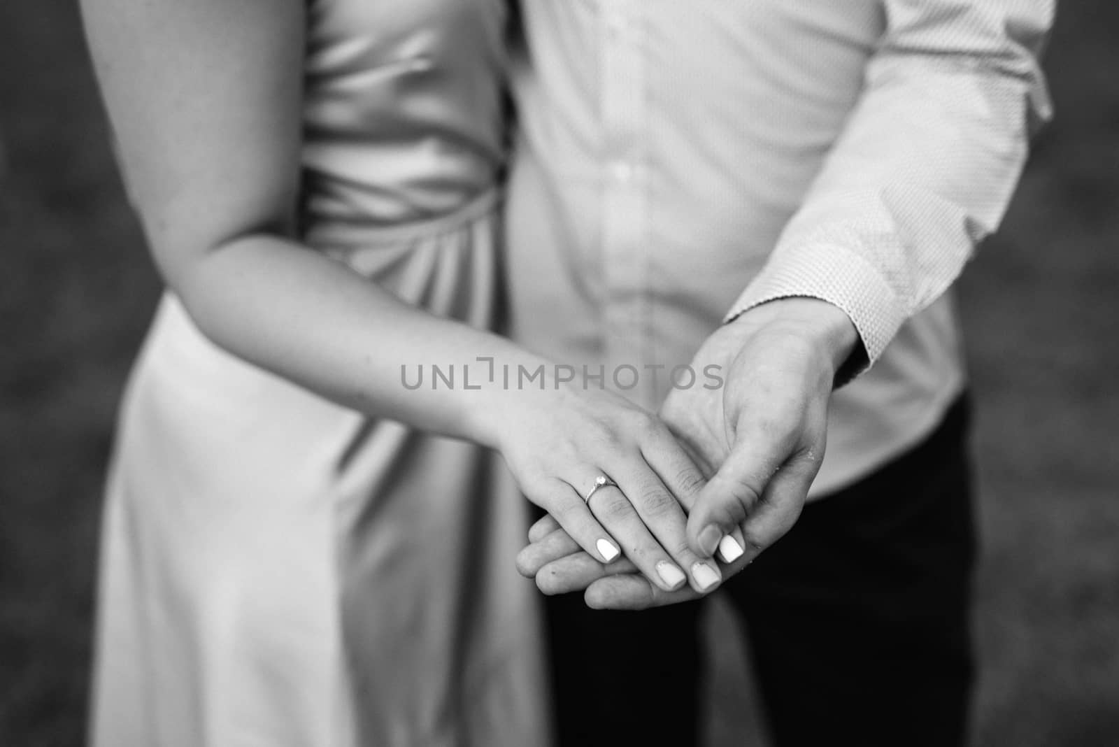 the bride and groom held hands and holding a red bouquet