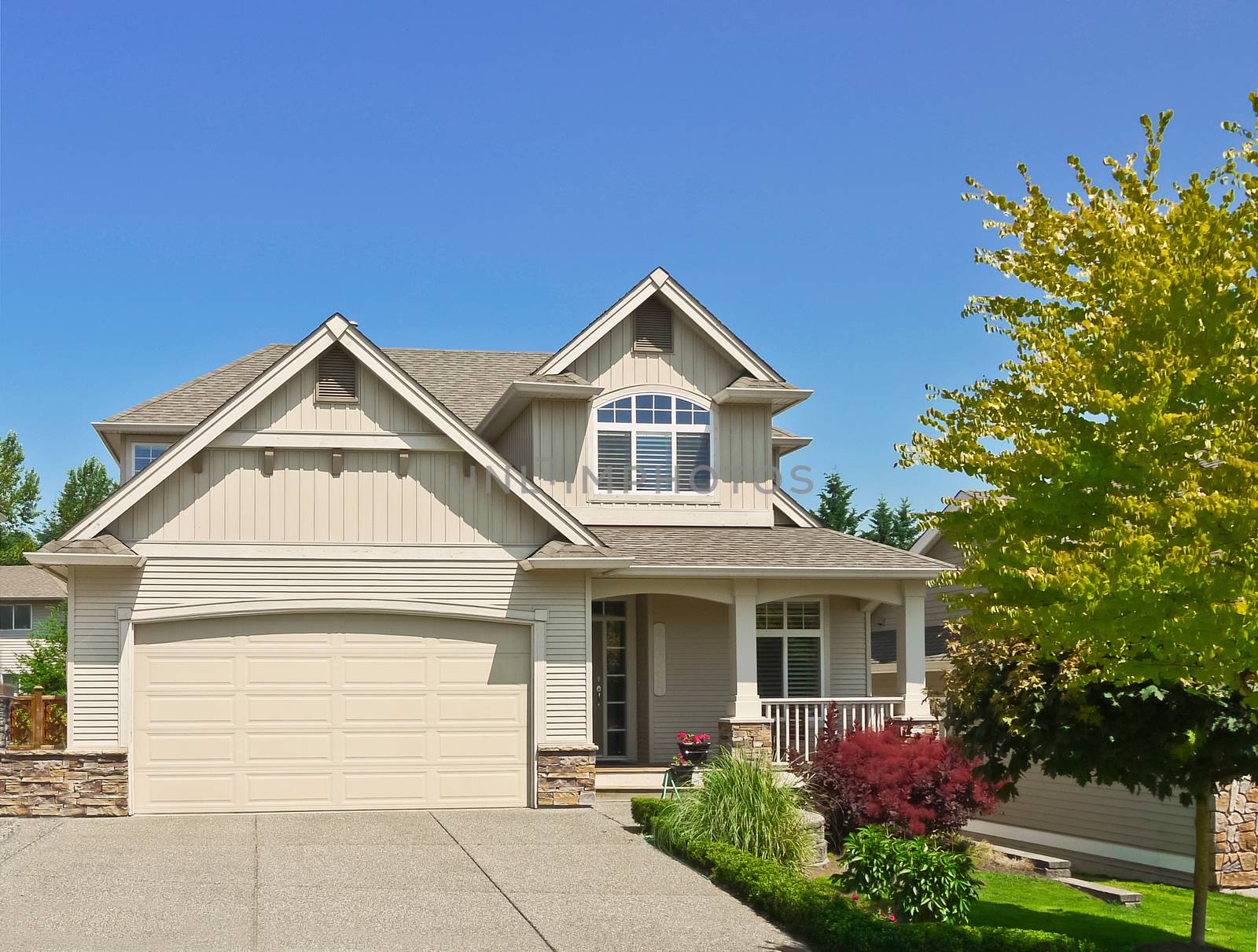 Average family house with concrete driveway to the garage on blue sky background