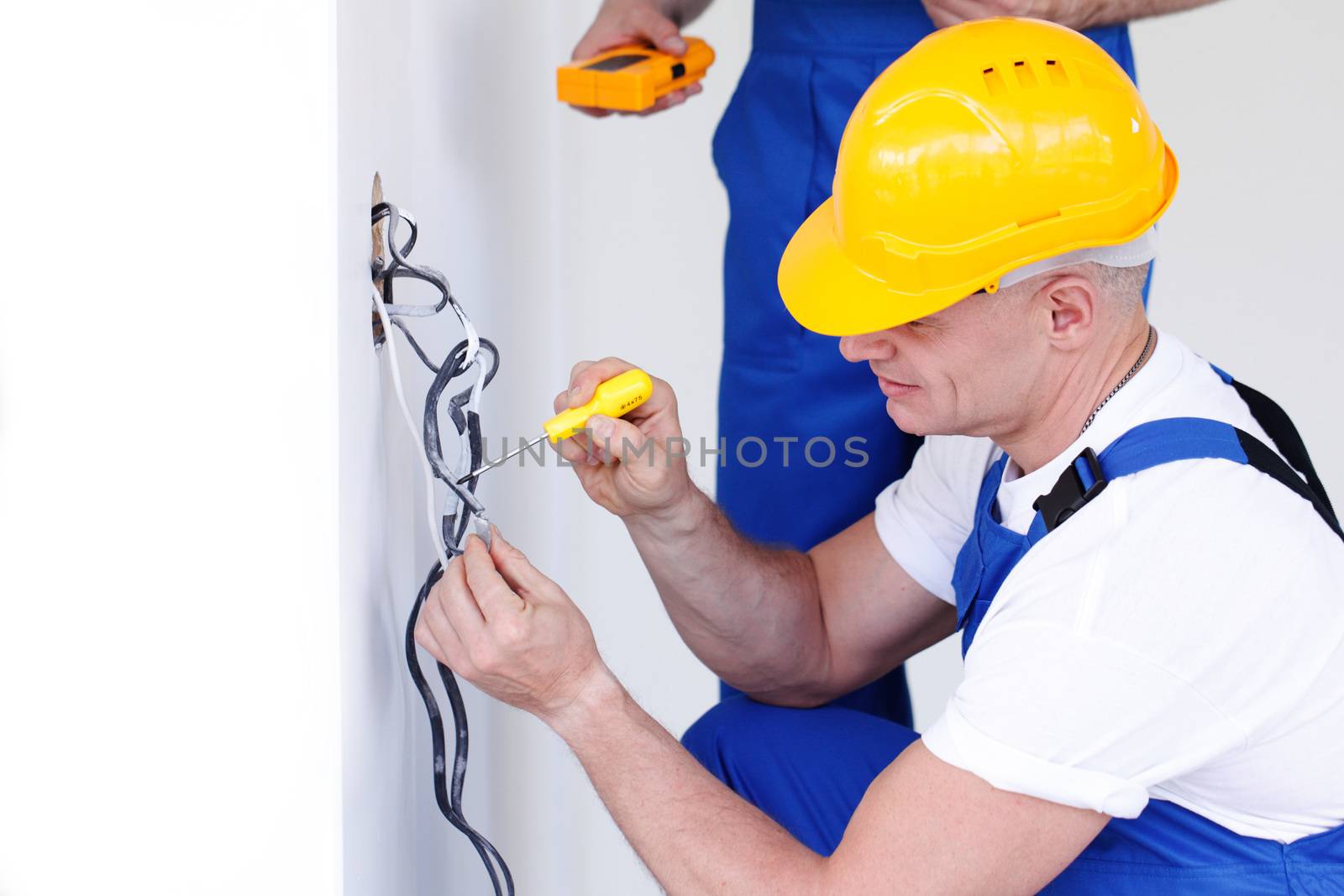 Electrician put electrical wires for wall socket using screw driver